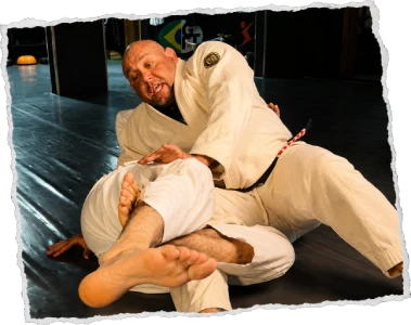 Mestre Fran do Carmo aplicando técnica de Jiu-Jitsu adulto no treino da Caveira BJJ
